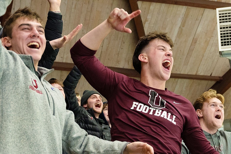 Students cheer on the women's hockey team as it plays at the rink.