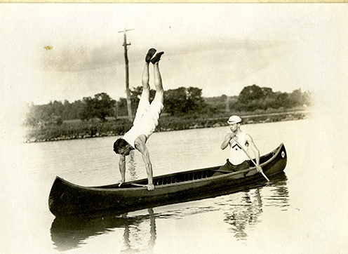 person doing a handstand in a canoe