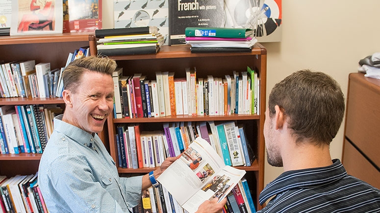 A professor shows a student a French book