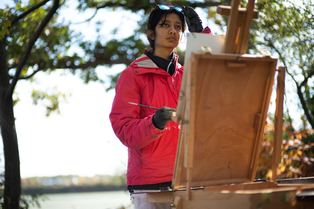 A student paints outdoors 