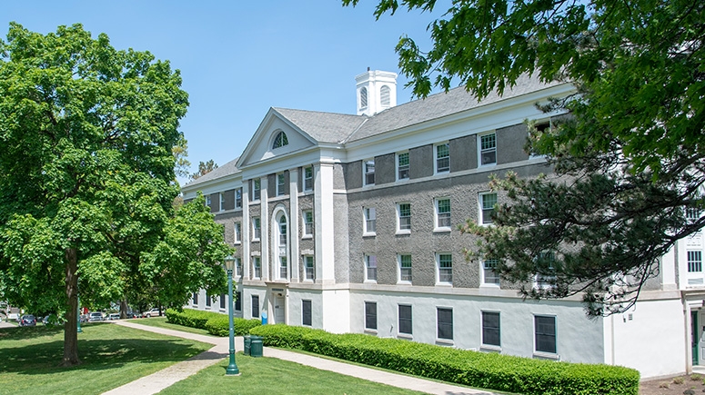 Outside facade of Richmond Hall with blue sky and green grass