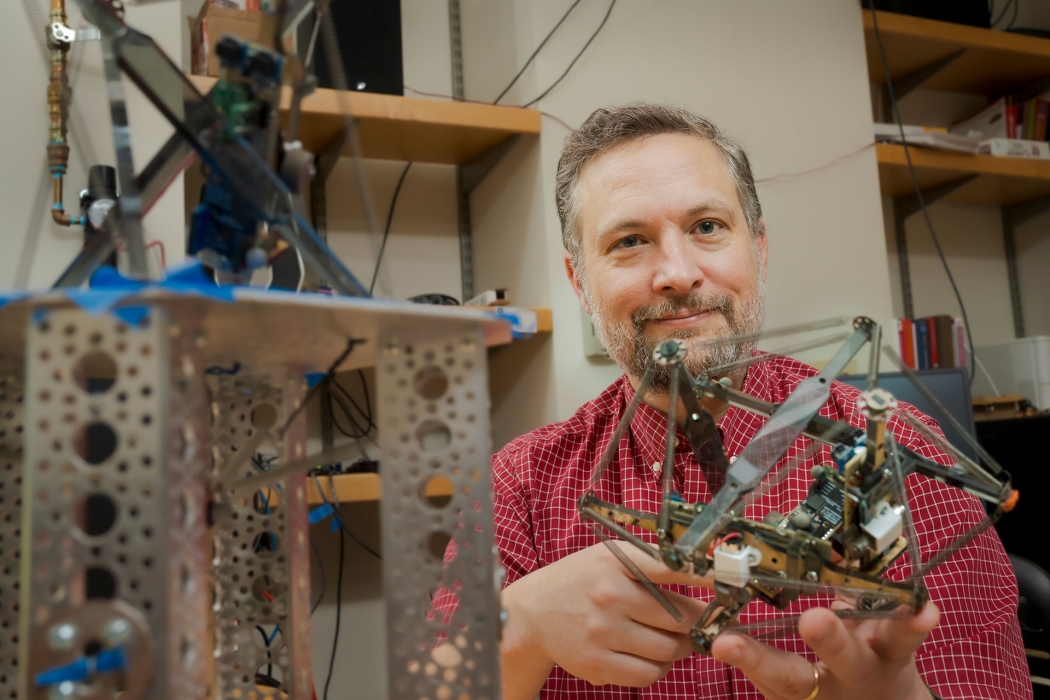 ohn Rieffel, professor of computer science and department chair shows off one of his ai robots