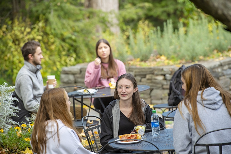 Students enjoy some coffee and conversation on the back patio of Reamer Campus Center