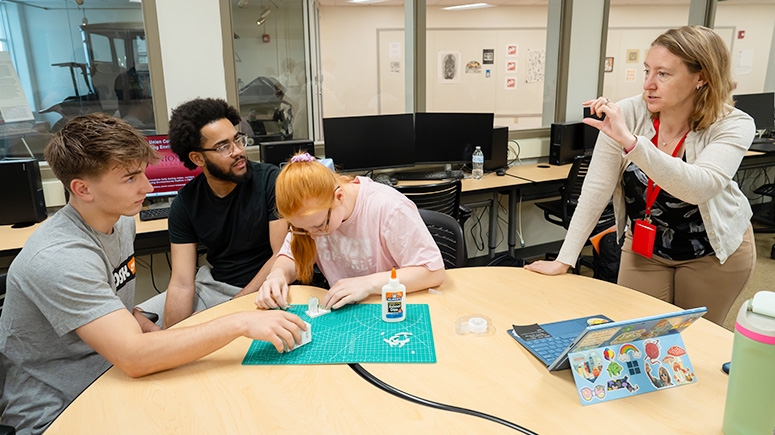 Carolyn Rodack, Associate Professor of Civil and Environmental Engineering, provides feedback to students constructing a small model during one of her introductory civil engineering classes.