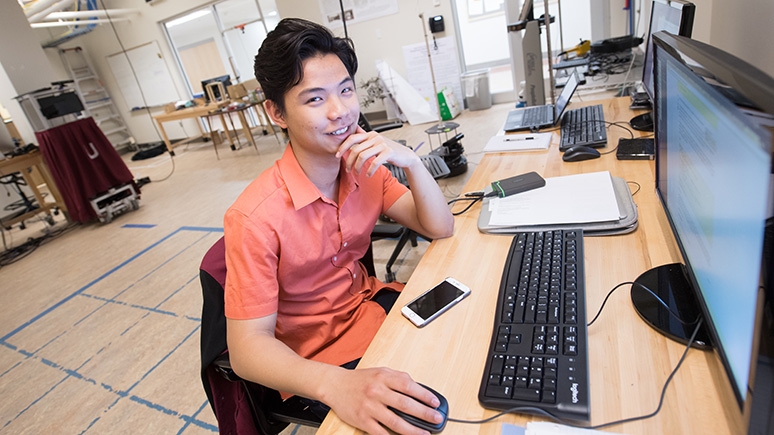  A student working at a desk in a computer science lab.