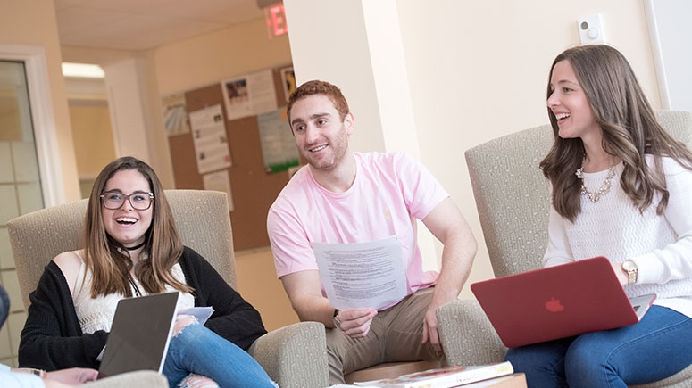 Students gathered in Karp Hall hallway engaged in friendly conversation.