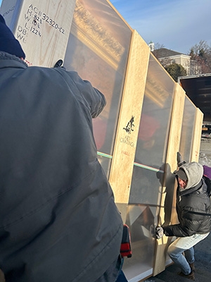 Workers carefully unload a historic portrait of Union's longtime president, Eliphalet Nott, which was restored at the Williamstown Art Conservation Center. The portrait will return to its space in the building that bears Nott's name.