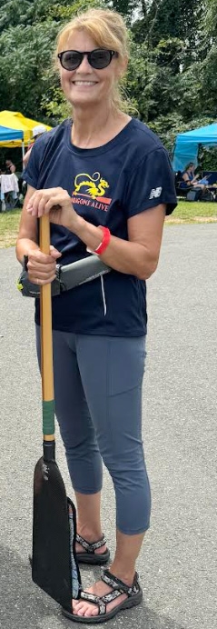 Traver poses with the paddle she uses in dragon boat racing. 