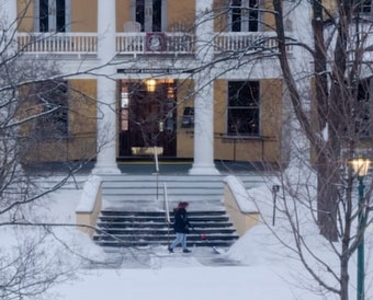 A member of the Facilities grounds crew shovels snow in front of Grant Hall Thursday morning. 