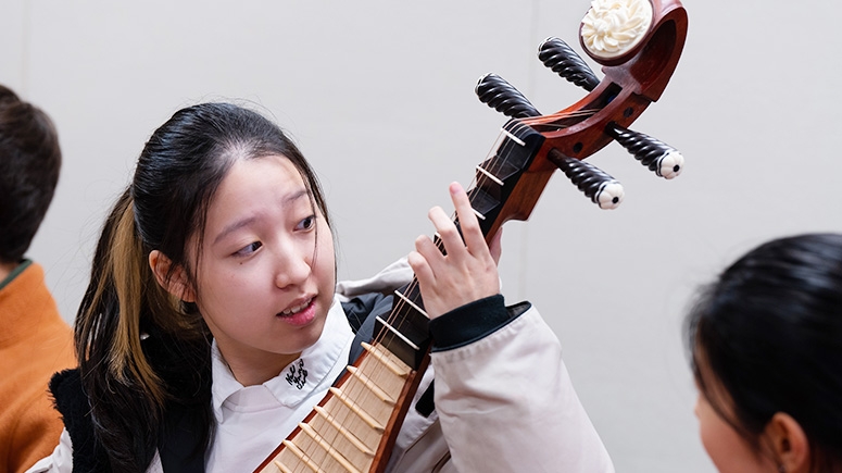 A studnet playing a balalaika