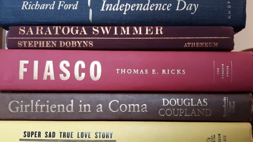 books are stacked to spell out a poem