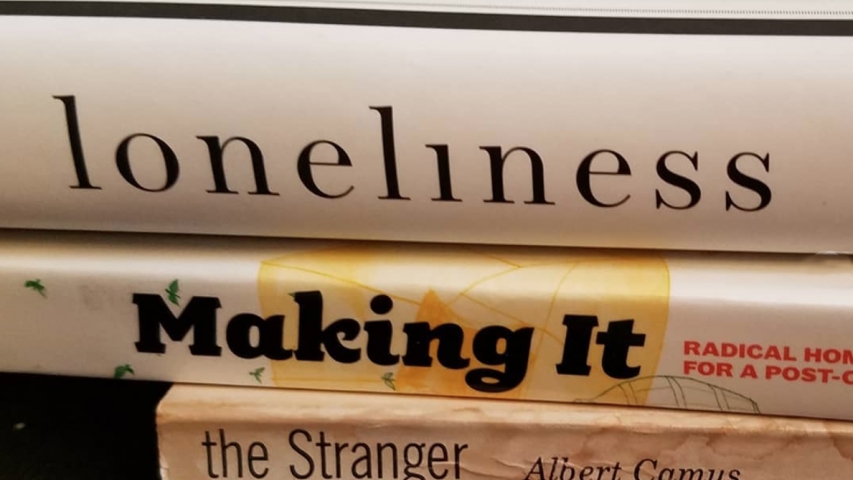 books are stacked to spell out a poem