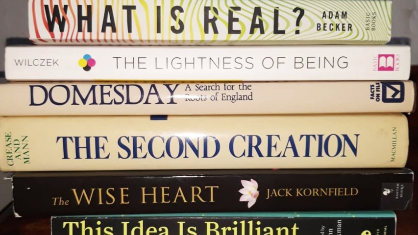 books are stacked to spell out a poem