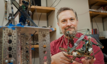 ohn Rieffel, professor of computer science and department chair shows off one of his ai robots