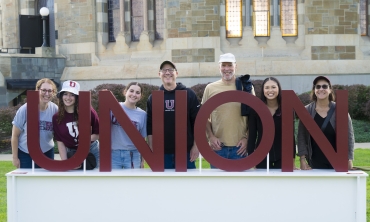 Union family and friends posing in front of Union sign