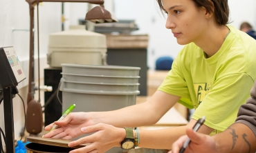 Students weigh and measure metal rings that are part of an civil enigneering experiement